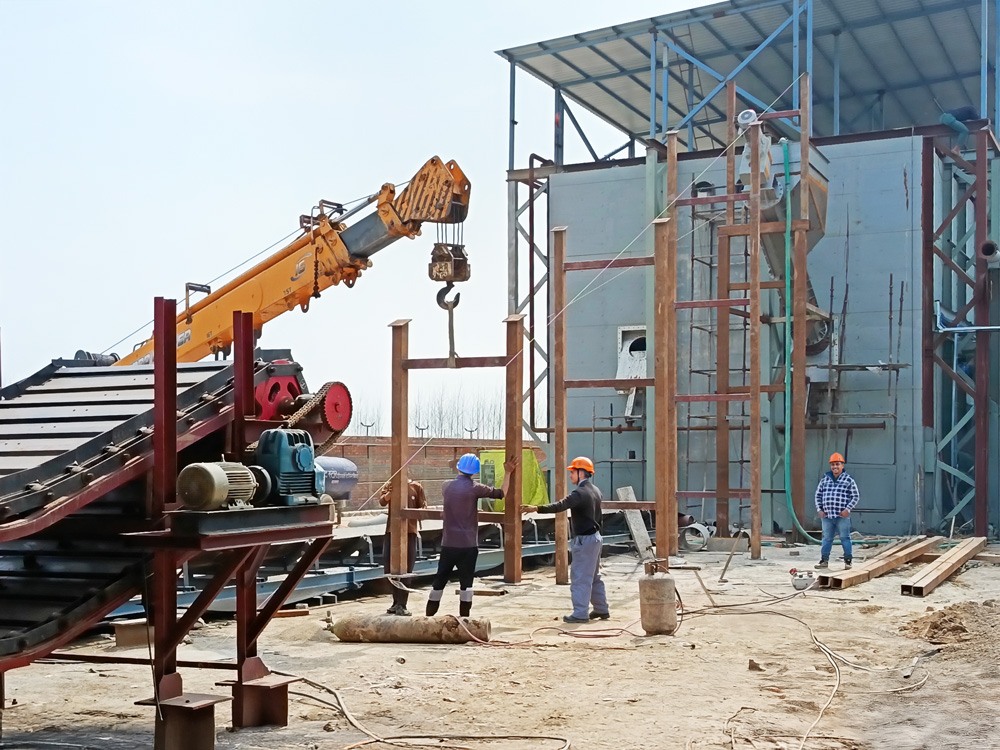 Technicians installing the feedscrew feeding conveyor system at the Arciplug® biogas plant in Haryana, part of the PLUG FLOW feedstock handling process.